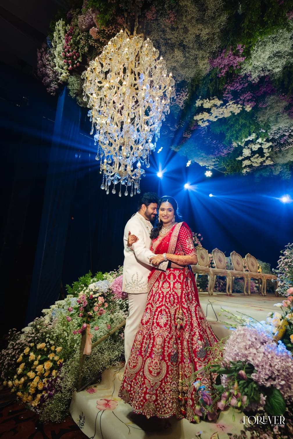 The couple beneath a crystal chandelier